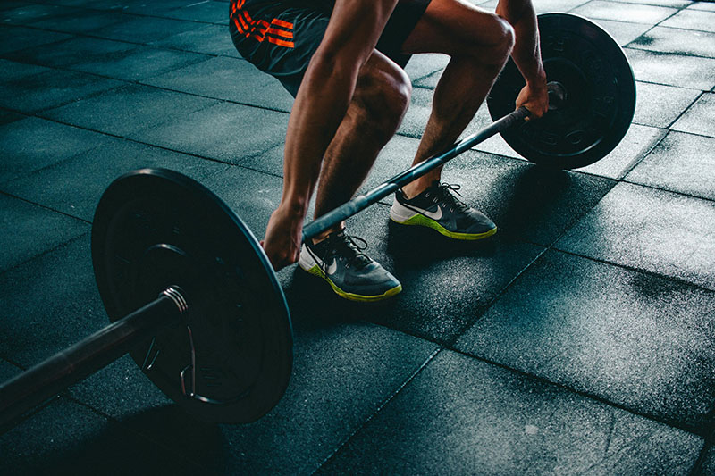 man deadlifting heavy weight at a gym